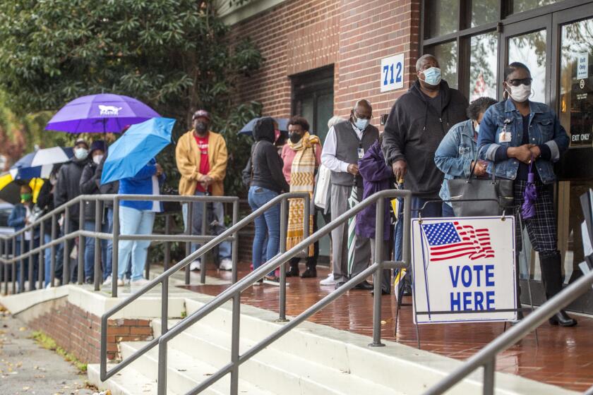 People wait in line on the first day of advance voting for Georgia's Senate runoff election at the Bell Auditorium in Augusta, Ga., Monday, Dec. 14, 2020. (Michael Holahan/The Augusta Chronicle via AP)