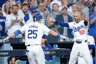 LOS ANGELES, CALIFORNIA - OCTOBER 20: Mookie Betts #50 of the Los Angeles Dodgers throws sunflower seeds on Tommy Edman #25 after Edman hit a two-run home run during the third inning in game six of the National League Championship Series against the New York Mets at Dodger Field on Sunday, Oct. 20, 2024 in Los Angeles. (Wally Skalij / Los Angeles Times)