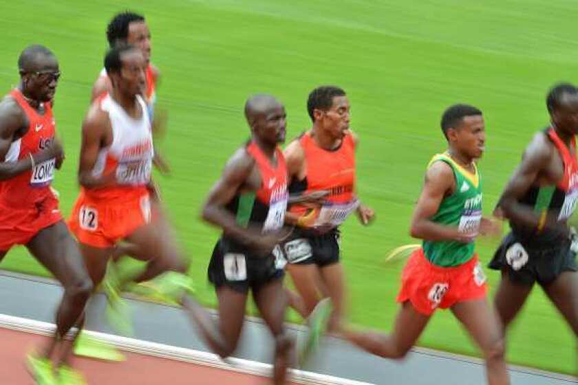 Lopez Lomong, left, competes in a men's 5000-meters heat Wednesday.