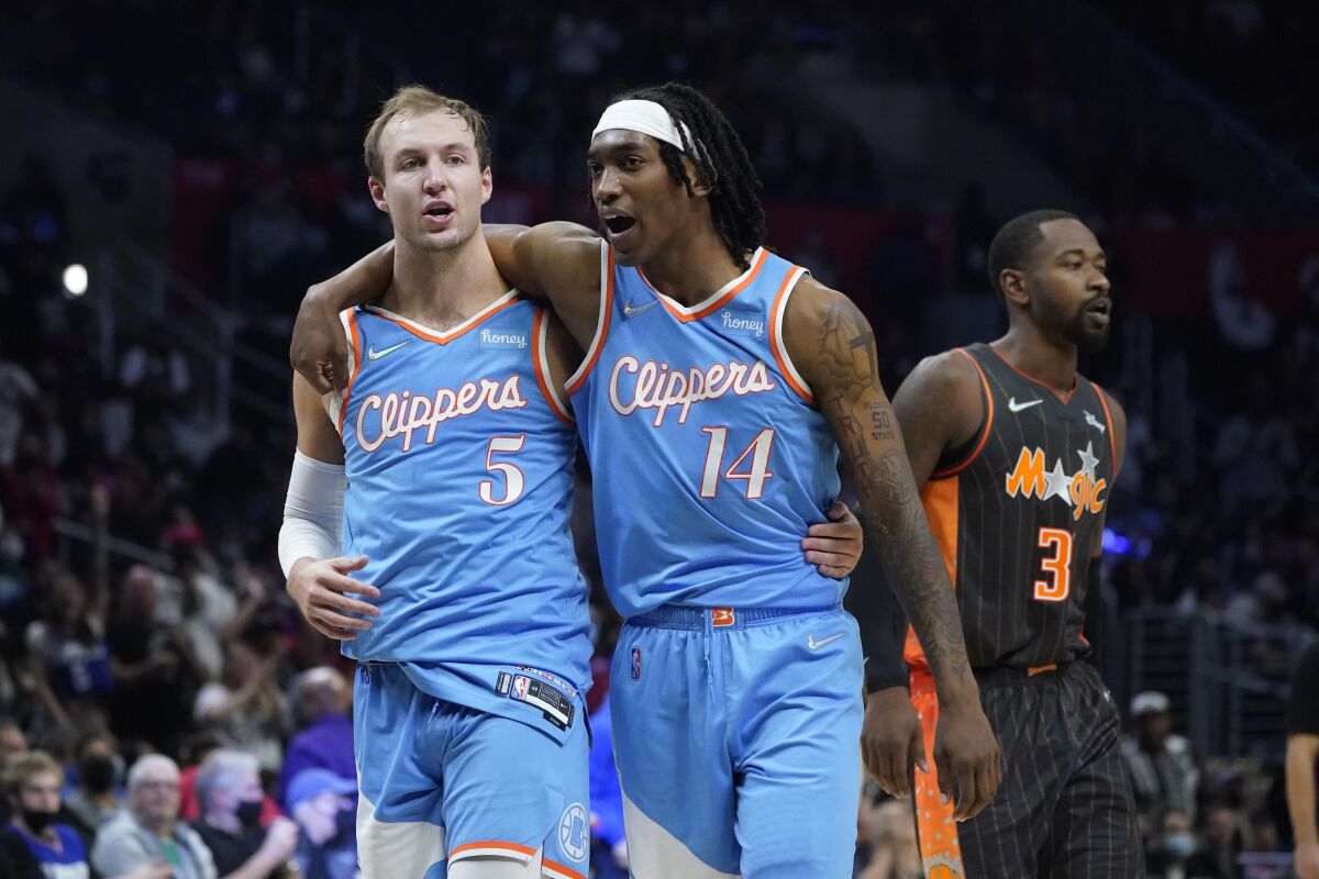 The Clippers' Luke Kennard, left, celebrates a three-pointer with Terance Mann during the second half Dec. 11, 2021.