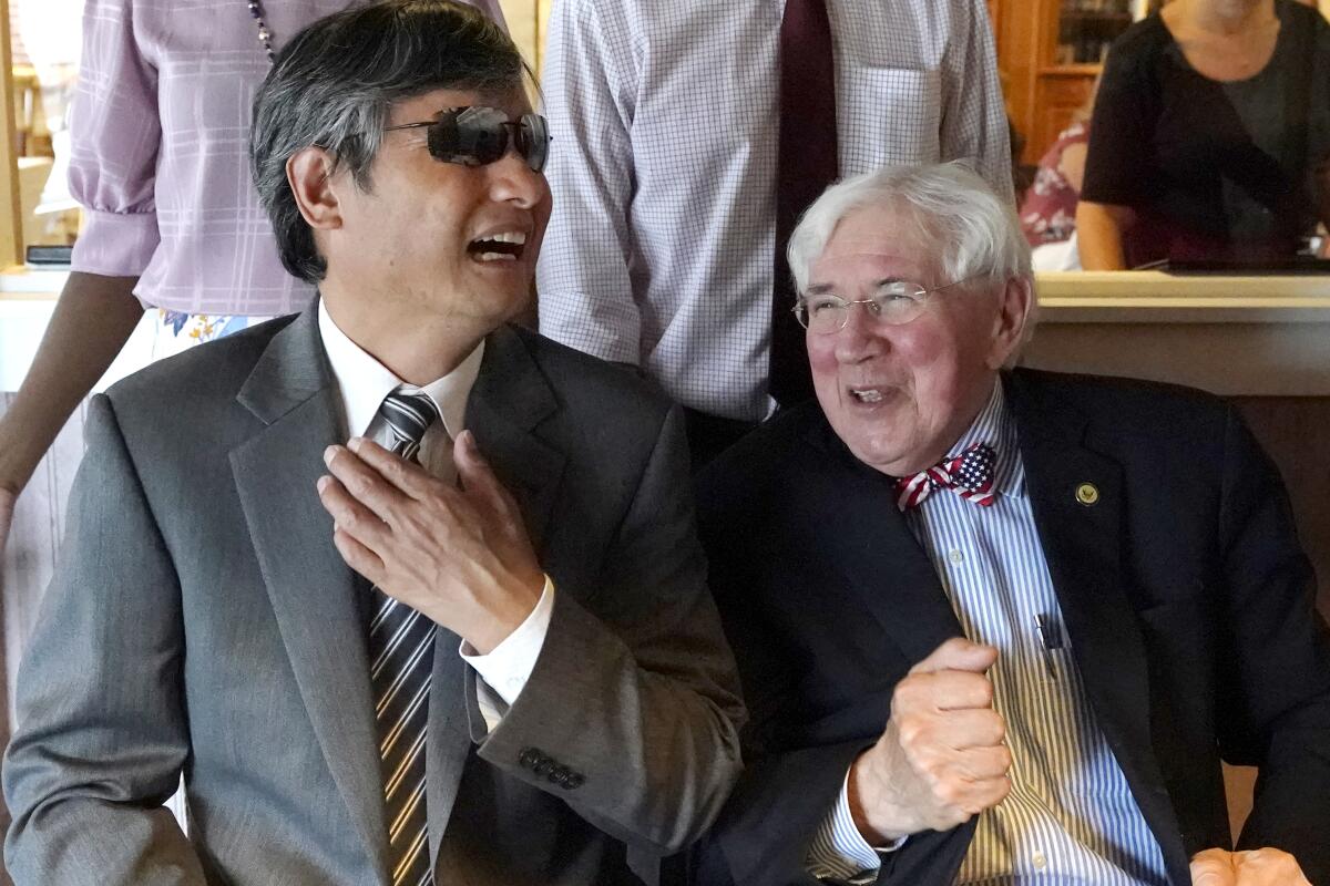 Chen Guangcheng, left, a blind Chinese dissident who escaped to the United States in 2012 and recently became an American citizen, laughs with one of his attorneys, George Bruno, Thursday, July 8, 2021, during a lunch to celebrate his citizenship in Manchester, N.H. (AP Photo/Elise Amendola)