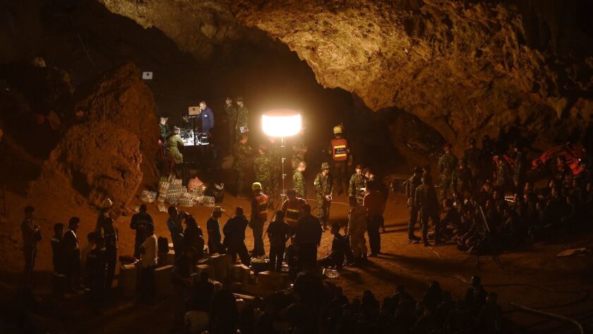 Thai soldiers relay electric cable deep into the Tham Luang Nang Non caves in Chiang Rai, northern Thailand, to locate 12 members of a boys' soccer team and their coach who went missing after the cave flooded.