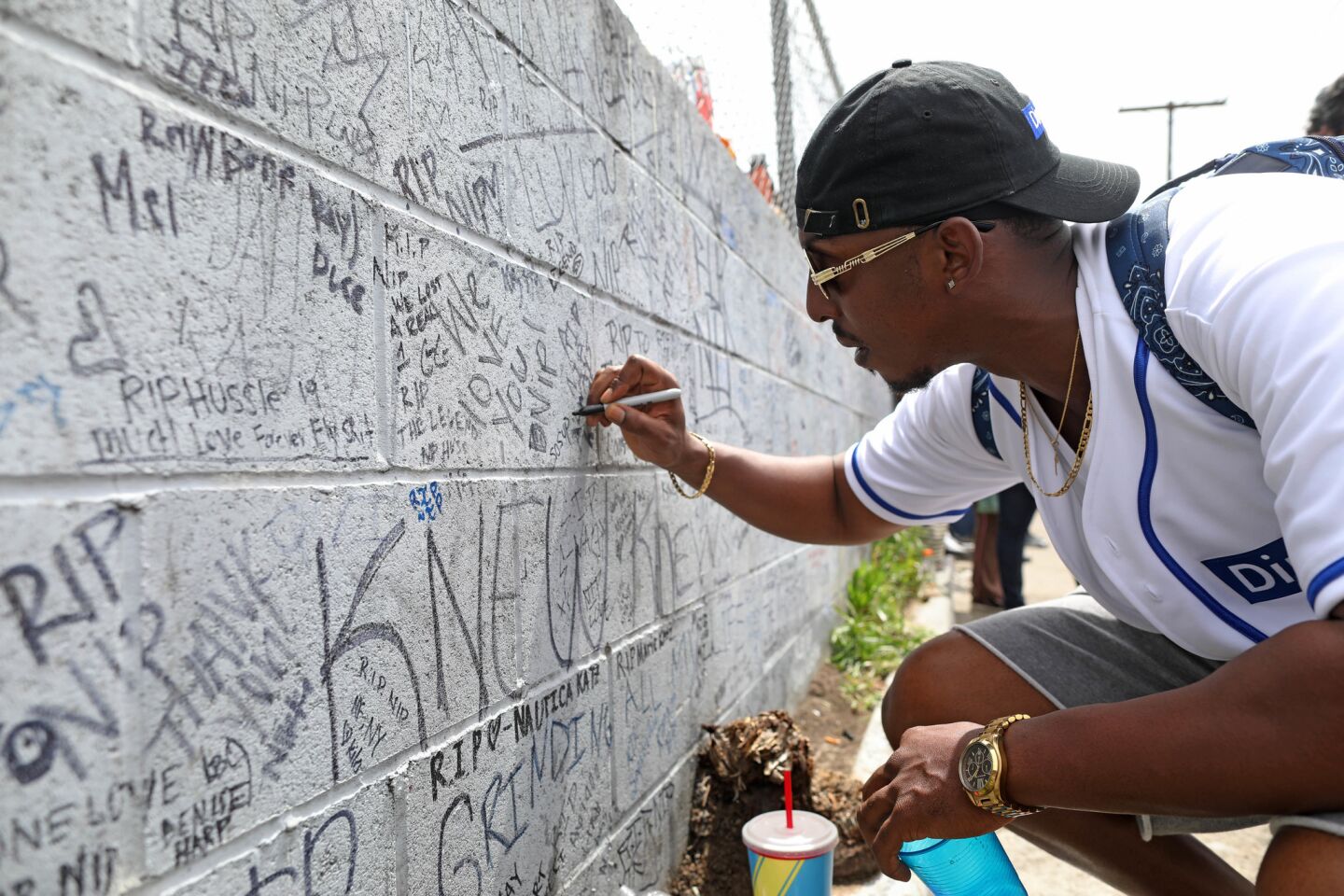 Herb Johnson of Los Angeles pays his respects to Nipsey Hussle on a wall near the late rapper's Marathon Clothing store.