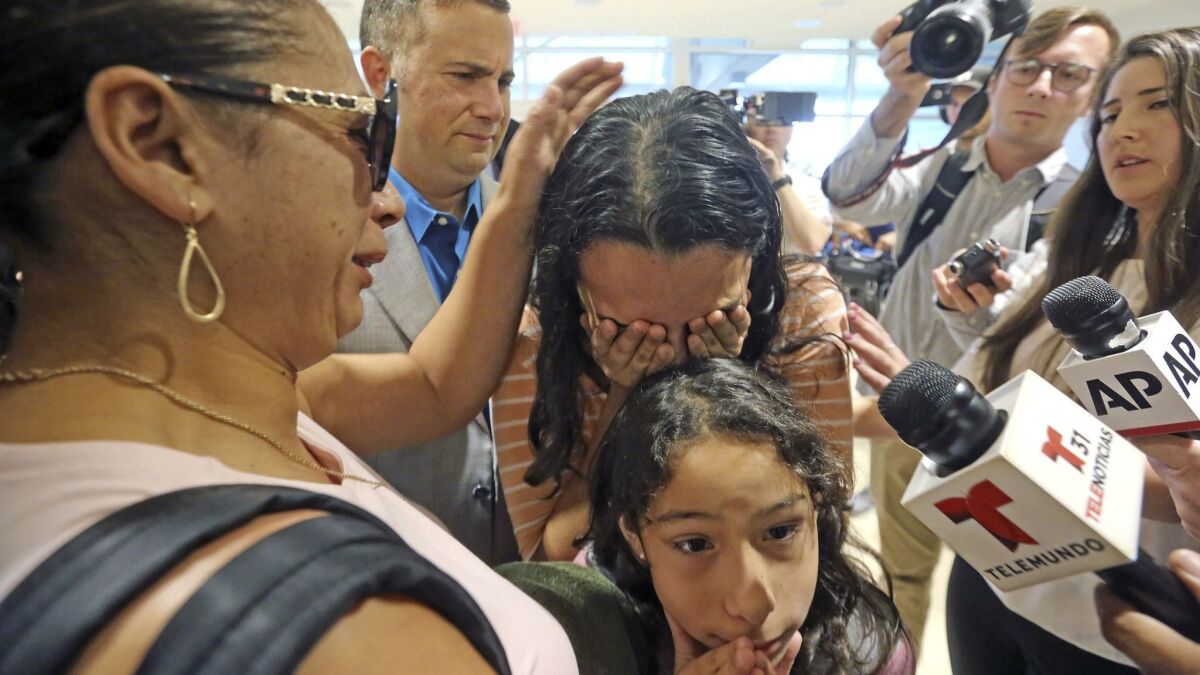 Alejandra Juarez, 39, left, says goodbye to her children, Pamela and Estela on Friday at the Orlando, Fla., airport.