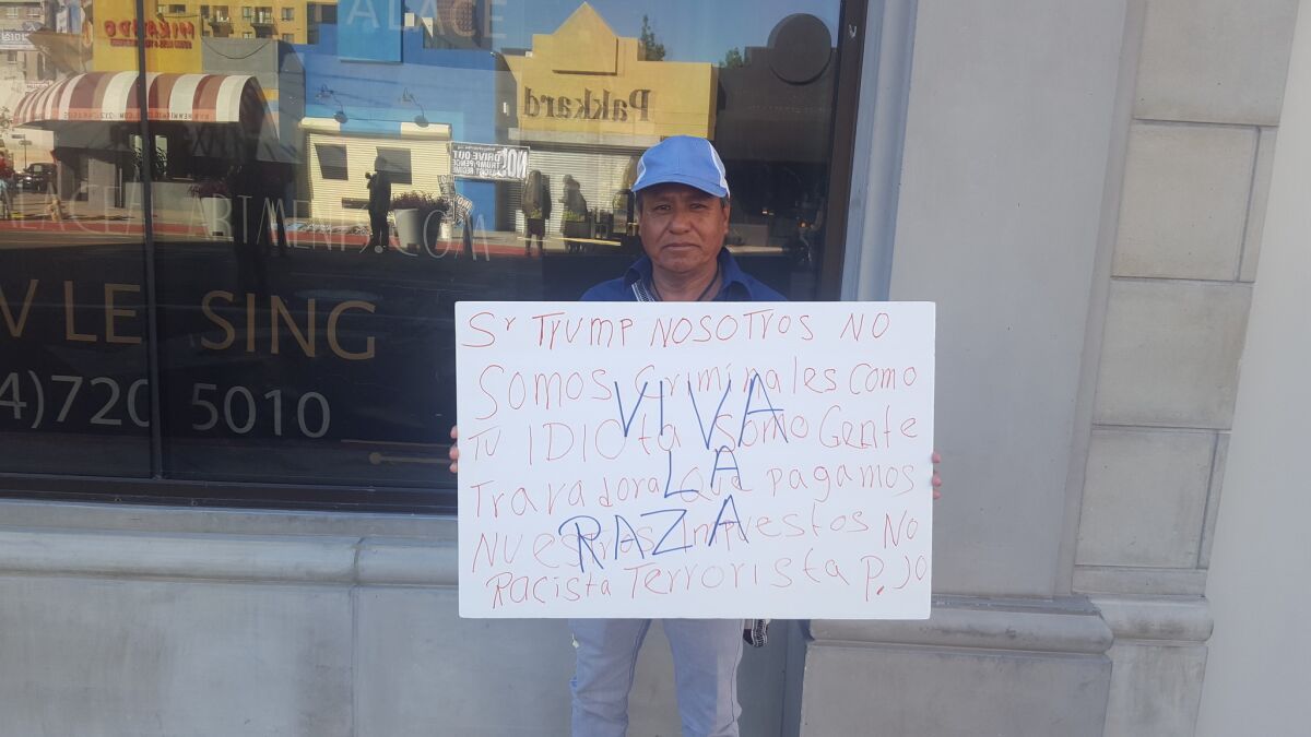 Juan Rodriguez, 57, holds up a homemade sign for Monday's May Day rally in downtown Los Angeles.