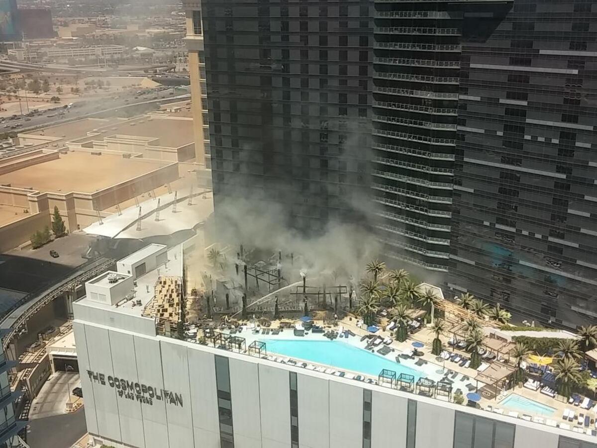 Humo sale a causa de un incendio en la zona de la piscina al aire libre en lo alto del hotel casino The Cosmopolitan, en Las Vegas, el sábado 25 de julio de 2015.