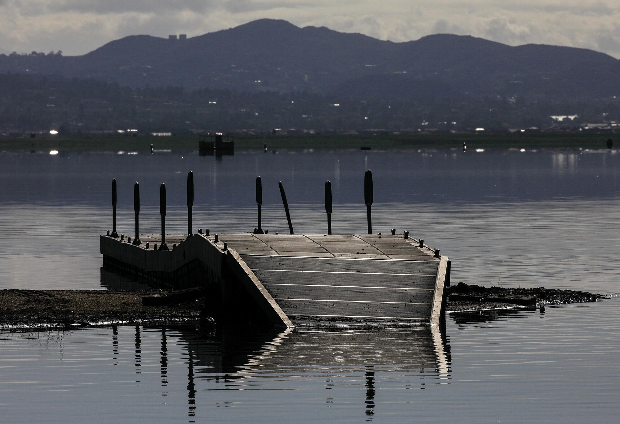 Un quai partiellement submergé s'élève hors de l'eau à Launch Pointe, au lac Elsinore.