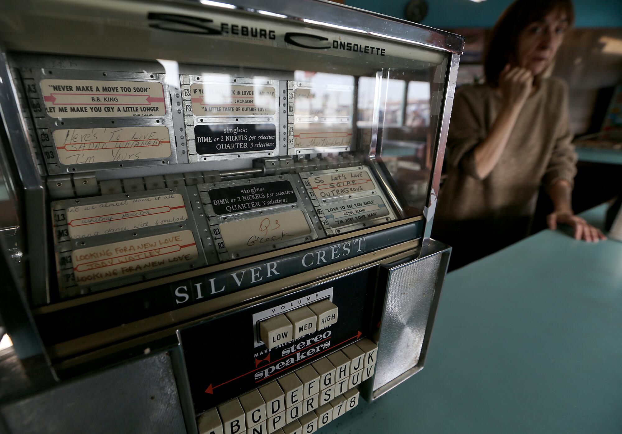 A jukebox machine with a playlist of golden oldies is fixed to the counter at the Silver Crest Donut Shop in San Francisco.