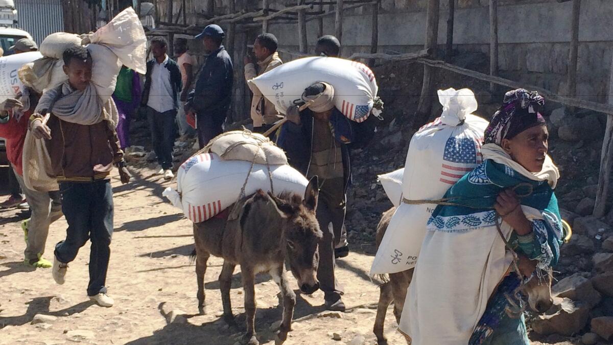 Families leave with supplies from the Estayesh food distribution site in Ethiopia in 2015. (David R. Kahrmann / Associated Press)
