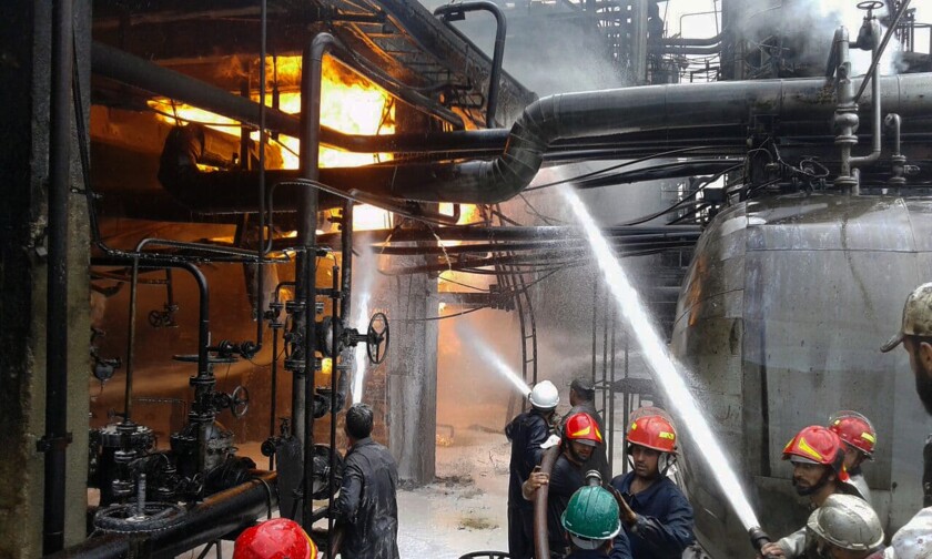 In this photo released by the Syrian official news agency SANA, firefighters put out a fire at the Homs Oil Refinery, in the central province of Homs, Syria, Sunday, May. 9, 2021. The fire came amid a series of mysterious attacks on vessels and oil facilities in Syria over the past months. The war-torn country has been suffering from fuel shortages in recent months. (SANA via AP)