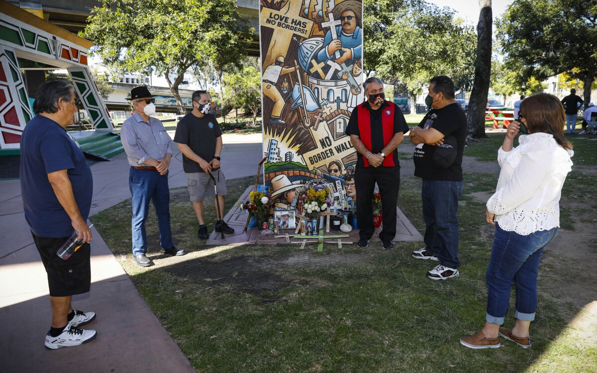 Friends stand at a memorial for Antonio Chavez Camarillo at Chicano Park.