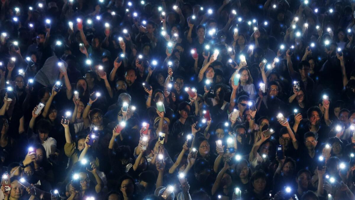 Attendees hold up their phones during a rally by mothers in Hong Kong on July 5.