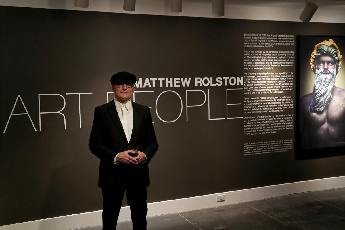 Photographer Matthew Rolston poses in front of his exhibit, "Art People: The Pageant Portraits."