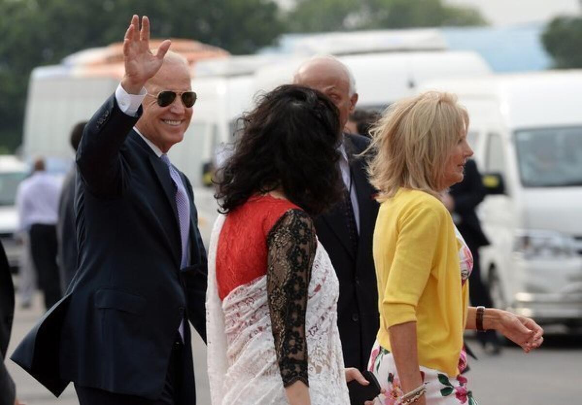 Vice President Joe Biden waves as he walks behind his wife, Jill Biden, and along with Indian officials after he arrived at the New Delhi airport Monday. Biden is in India on a four-day visit designed to revive momentum in flagging diplomatic ties and fire up bilateral trade.