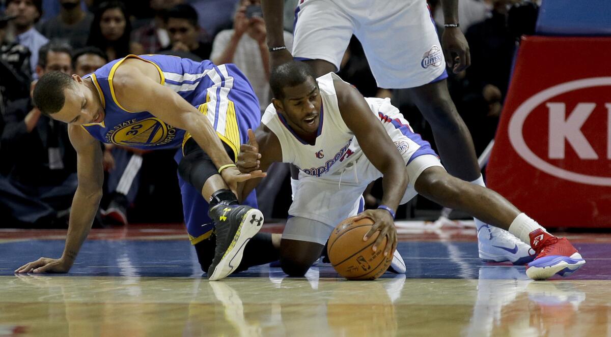 Chris Paul, right, battles Golden State's Stephen Curry for a loose ball during an Oct. 7 exhibition game at Staples Center.