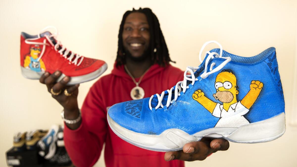 Los Angeles Clippers forward Montrezl Harrell holds a pair of Air Jordan XX9s customized by Amezcua that are part of Harrell's sneaker collection.