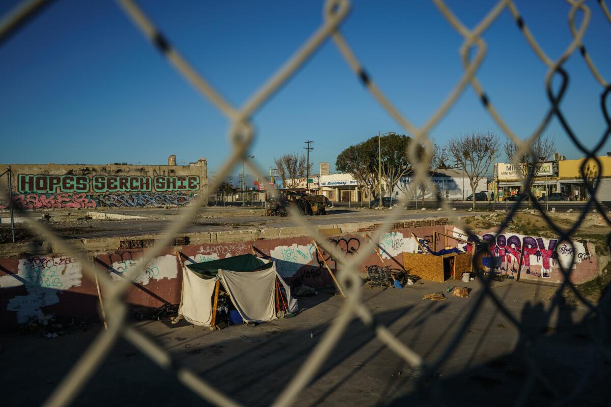 Homeless encampment in a property owned by Neighborhood Housing Services in Los Angeles. A graffiti-covered building owned by retired dentist Alan Kleinman is in the background.