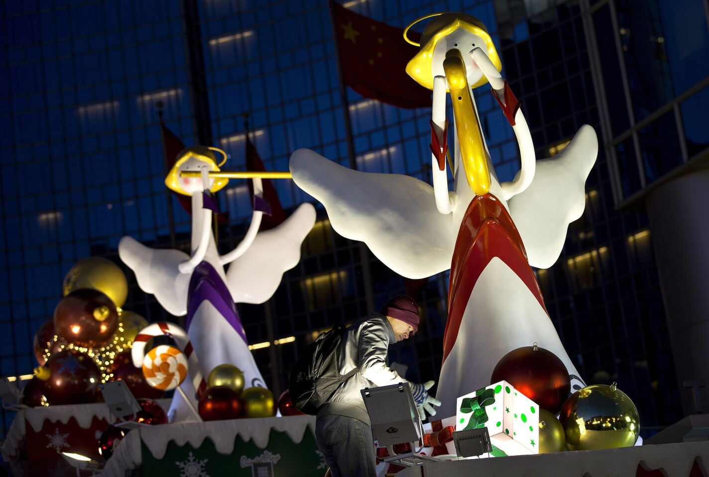 A worker tends to the winged angels Christmas display outside a shopping mall.