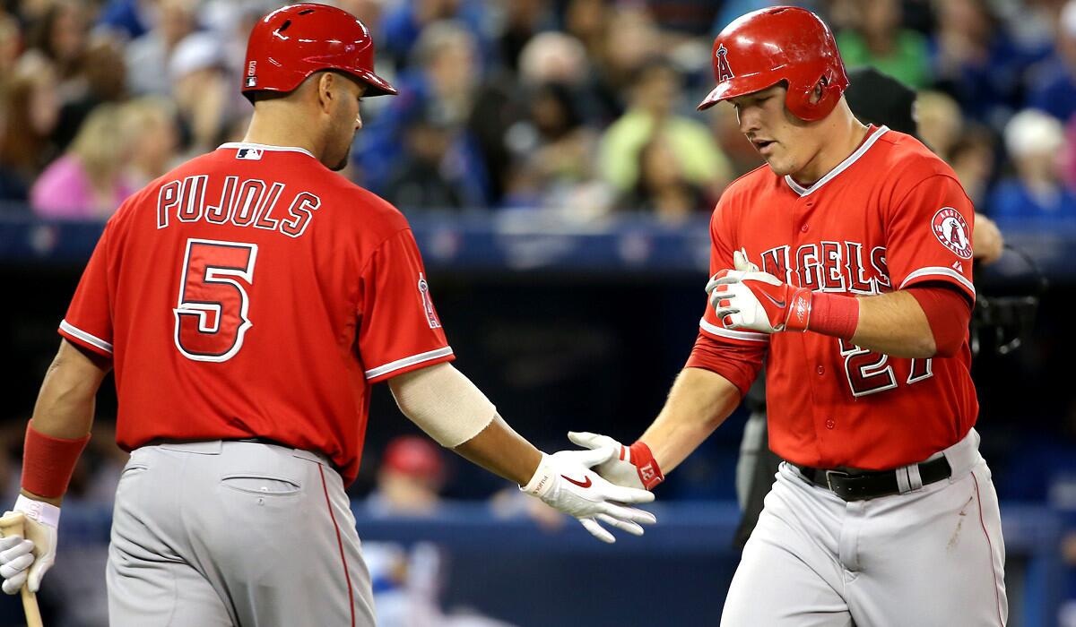 Angels center fielder Mike Trout (27) is congratulated by first baseman Albert Pujols after hitting a home run against the Blue Jays in the third inning Friday night.