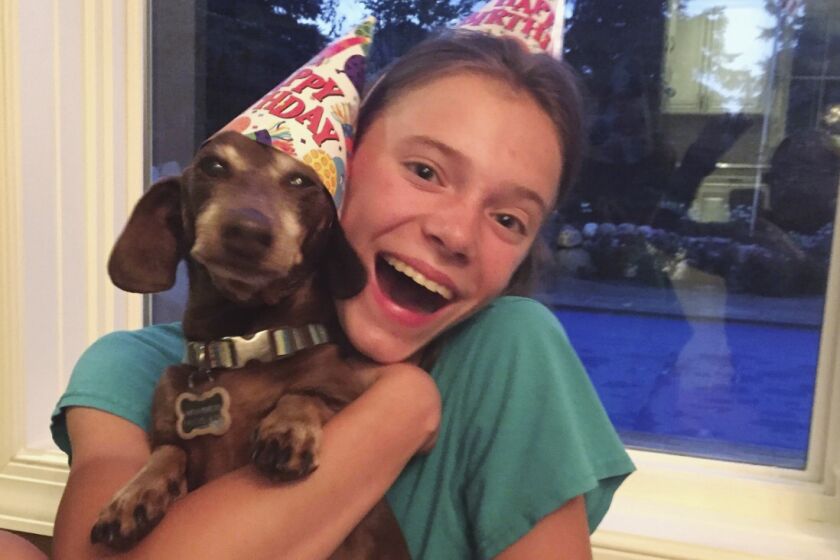 This August 2020 photo provided by Peyton Crest shows her with her dog at home in Minnetonka, Minn. The 18-year-old ays she developed anorexia before the pandemic but has relapsed twice since it began. ‘’It was my junior year, I was about to apply for college,’’ Crest says. Suddenly deprived of friends and classmates, her support system, she’d spend all day alone in her room and became preoccupied with thoughts of food and anorexic behavior. (Courtesy Peyton Crest via AP)