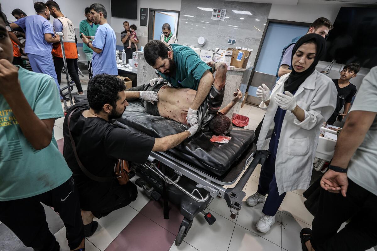 Doctors examining an injured man at Shifa Hospital in Gaza City