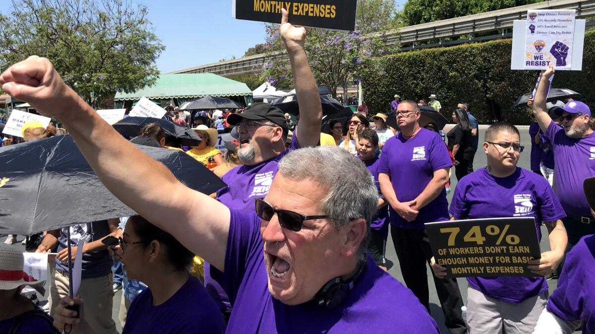 After a march into the entrance of the theme park early this month, Disneyland custodial worker Robin Canada chants along with fellow Disneyland workers from unions protesting the lack of progress in negotiations with Disney.