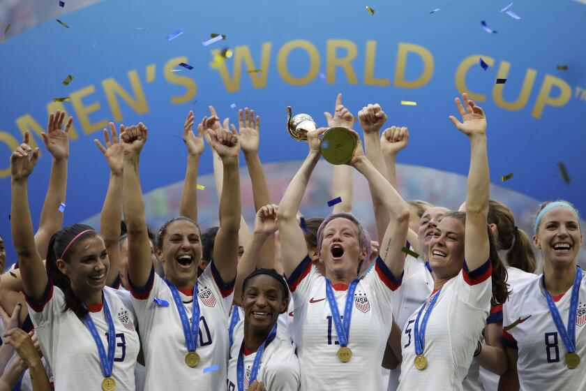 FILE - In this July 7, 2019, file photo, United States' Megan Rapinoe lifts up a trophy after winning the Women's World Cup final soccer match between U.S. and The Netherlands at the Stade de Lyon in Decines, outside Lyon, France. “We’ve done exactly what we set out to do, done exactly what we wanted to do, said what we feel,” said Rapinoe. “I know sometimes my voice is louder, but everybody is in this together.” (AP Photo/Alessandra Tarantino, File)