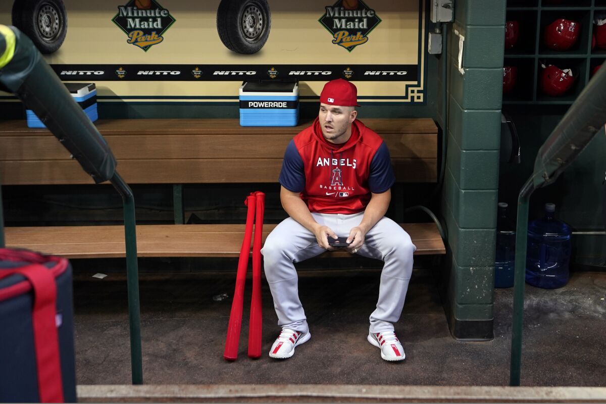 Angels star Mike Trout sits in the dugout before Monday's game against the Houston Astros.