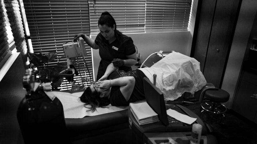 A nurse comforts a patient after an abortion procedure. A new survey of obstetricians and gynecologists finds that 72% of them had a patient who wanted an abortion in the past year.