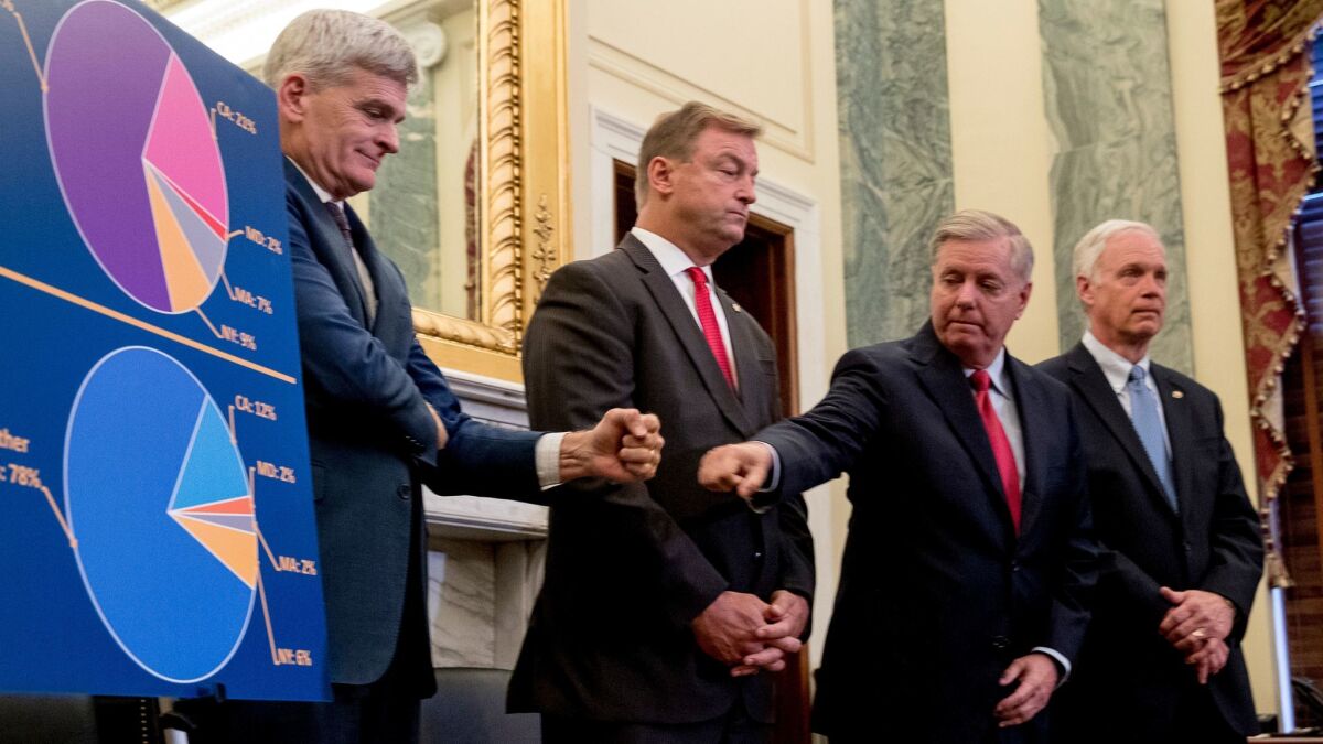 Sen. Bill Cassidy, R-La., left, and Sen. Lindsey Graham, R-S.C., second from right, fist bump each other during a news conference on Capitol Hill in Washington on Sept. 13.