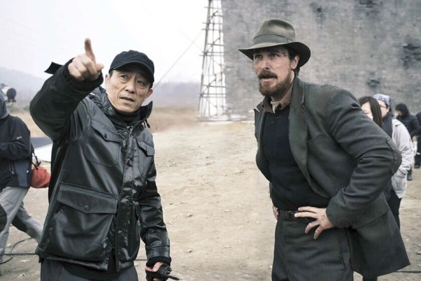 Director Zhang Yimou works with actor Christian Bale on "The Heroes of Nanking."