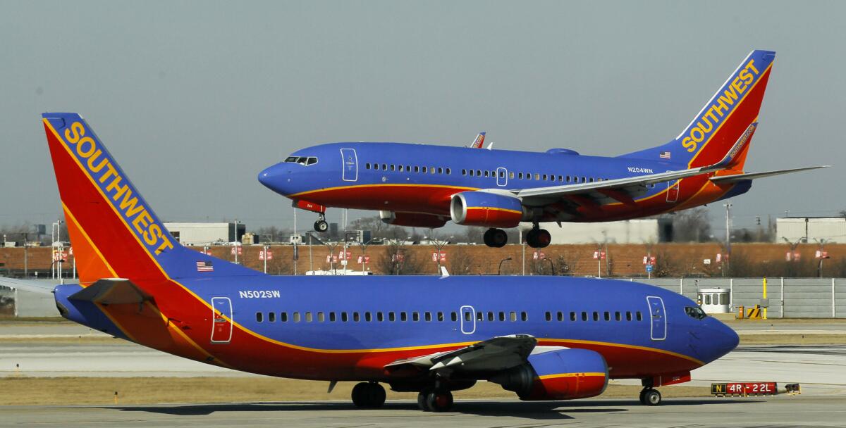 A Southwest Airlines Boeing 737 waits to take off at Chicago's Midway Airport as another lands. Southwest has improved its on-time performance over the last year.