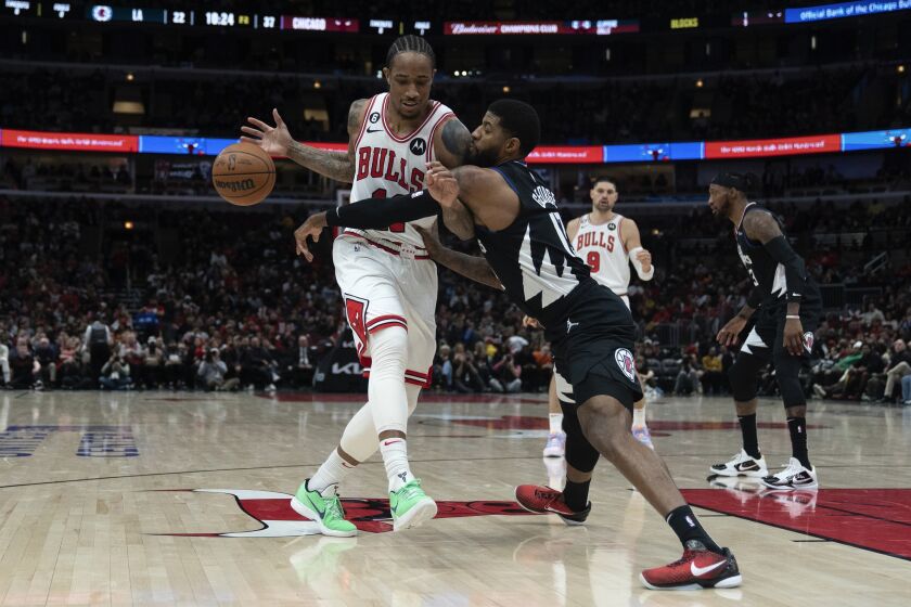 Los Angeles Clippers guard Paul George, right, slaps the ball away from Chicago Bulls forward DeMar DeRozan during the first half of an NBA basketball game Tuesday, Jan. 31, 2023, in Chicago. (AP Photo/Erin Hooley)