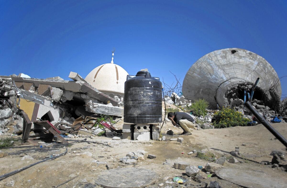 A Palestinian man prays next to the rubble of a mosque in the Khan Younis district. More than 100,000 homes across Gaza were destroyed or badly damaged in the fighting between Israel and Hamas.