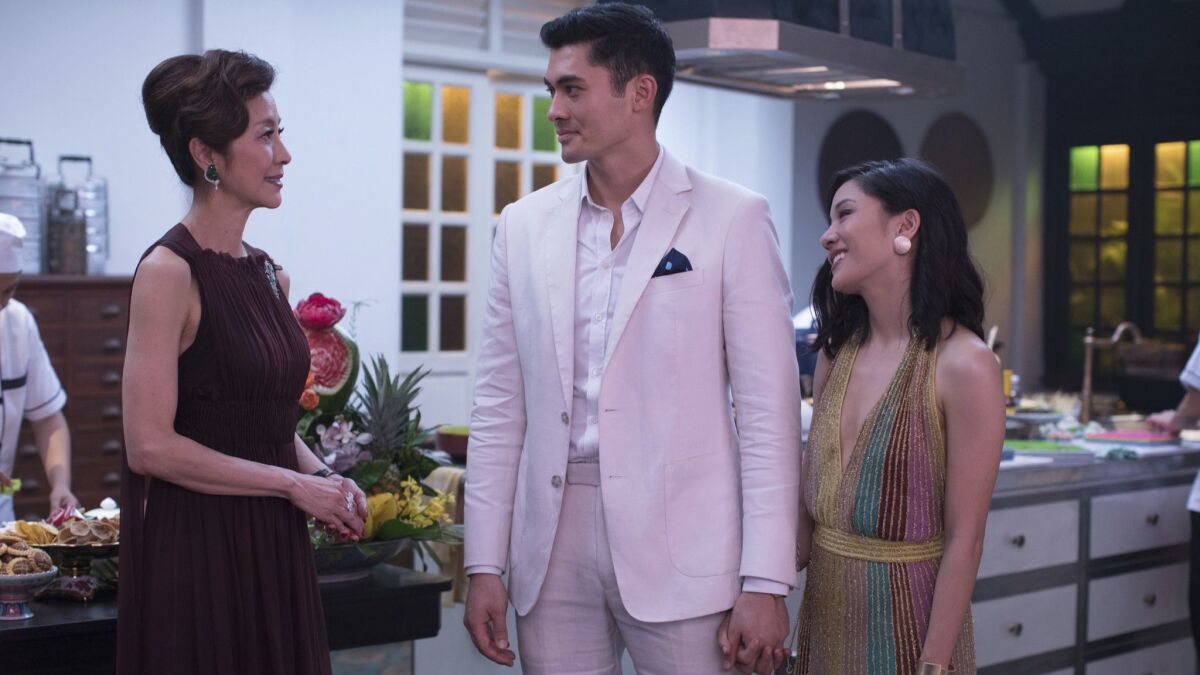 This image released by Warner Bros. Entertainment shows Michelle Yeoh, from left, Henry Golding and Constance Wu in a scene from the film "Crazy Rich Asians." (Sanja Bucko/Warner Bros. Entertainment via AP)