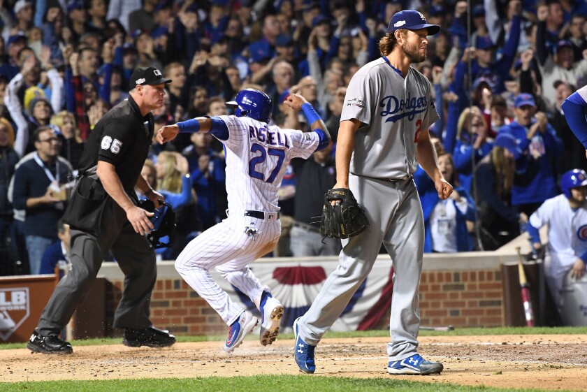 Dodgers pitcher Clayton Kershaw walks back to the mound as Cubs shortstop Addison Russell scores a run in the second inning of Game 6.