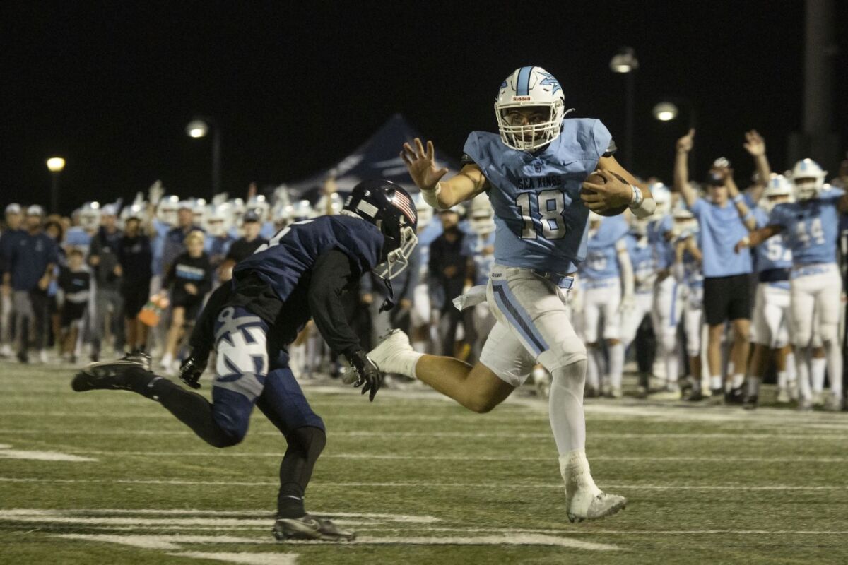 Corona del Mar’s David Rasor runs the ball for a first down against Newport Harbor in the Battle for the Bell game.