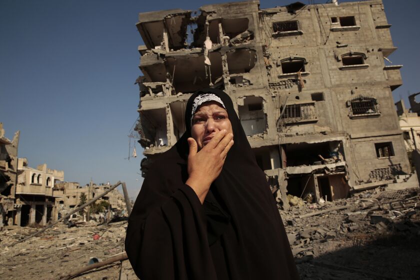 A woman cries as she tries to return to her home in the conflict-shattered Shejaiya neighborhood of Gaza City on July 26.