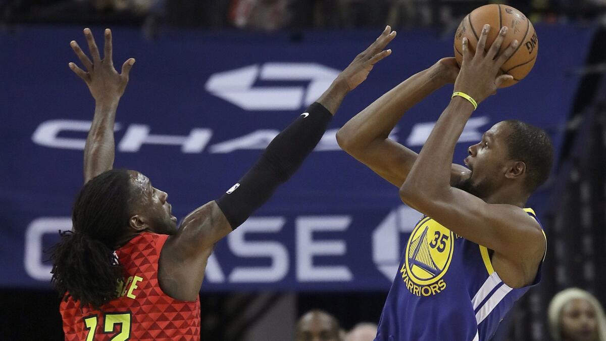 Golden State Warriors forward Kevin Durant (35) shoots against Atlanta Hawks forward Taurean Prince (12) during the first half.