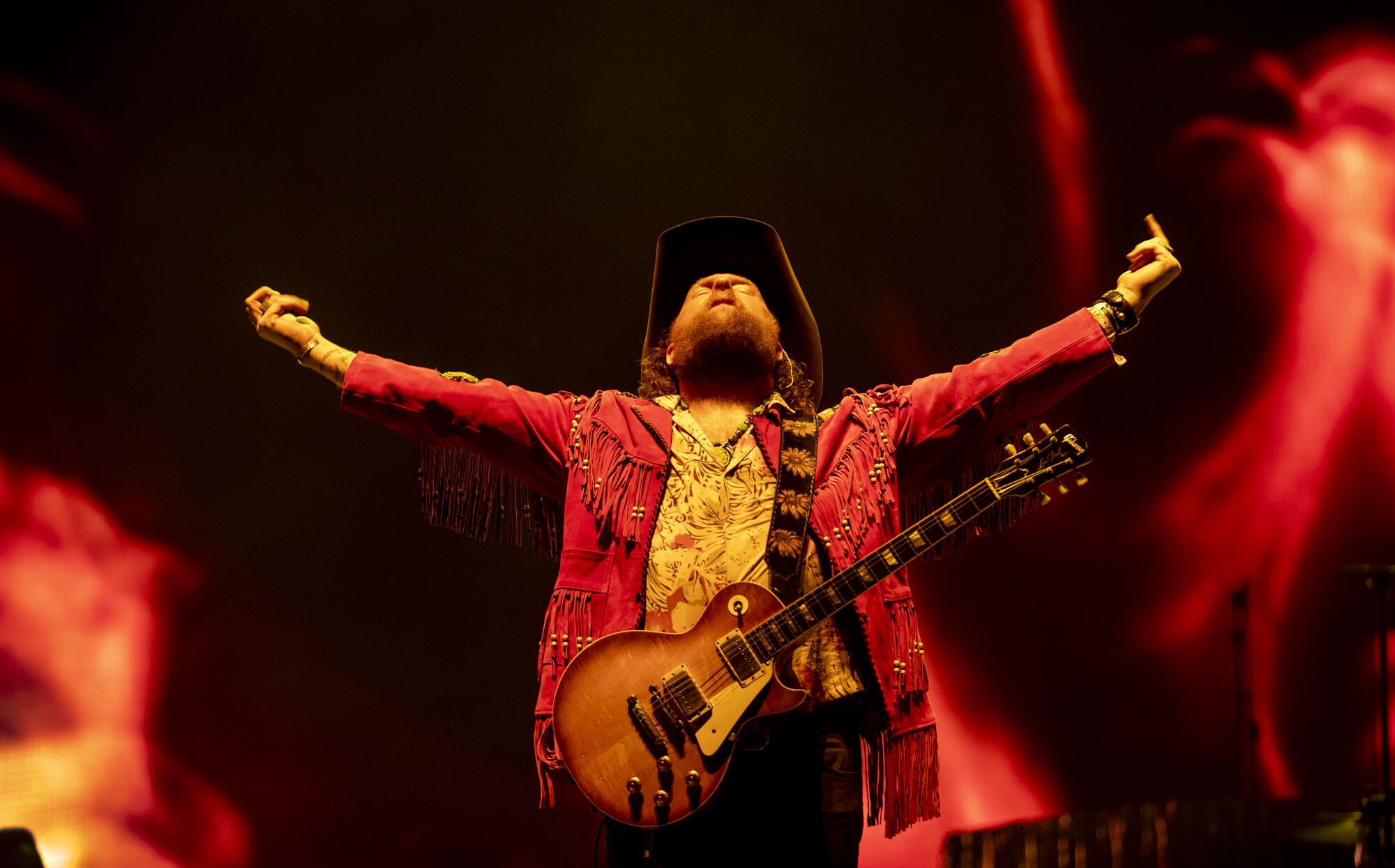 John Osborne looks up as he raises his arms while performing onstage