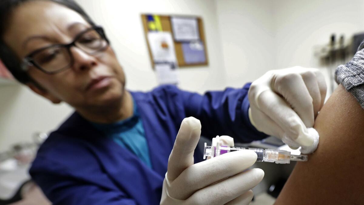 Ana Martinez, a medical assistant at the Sea Mar Community Health Center in Seattle, gives a patient a flu shot.