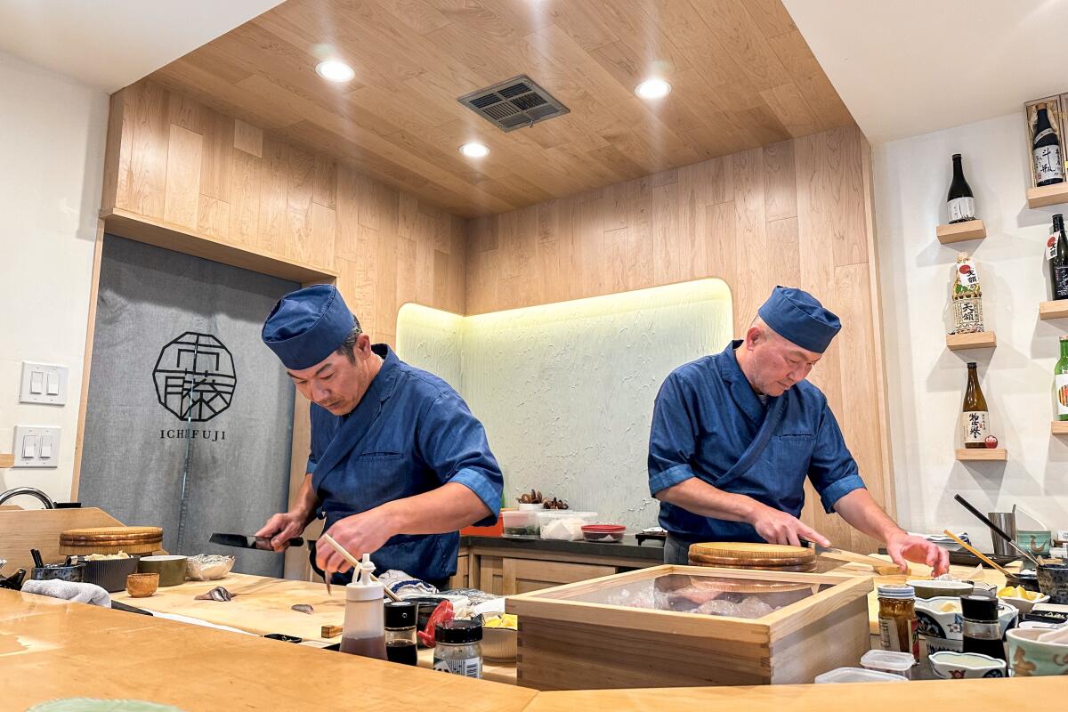 Chefs Hiroshi Ichikawa and Masato Fujita work behind the bar of their San Diego sushi restaurant Ichifuji