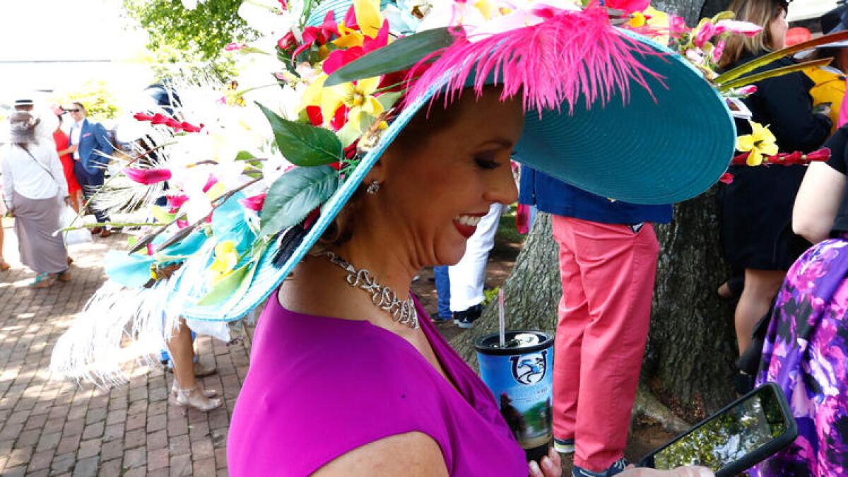 A woman checks her phone after arriving at Churchill Downs for the 143rd running of the Kentucky Derby. To see more images, click on the photo above.