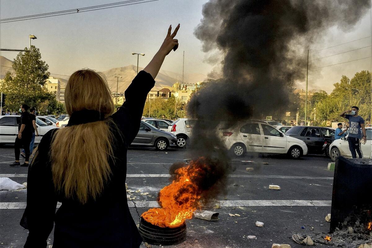 Woman makes victory sign at protest in Tehran
