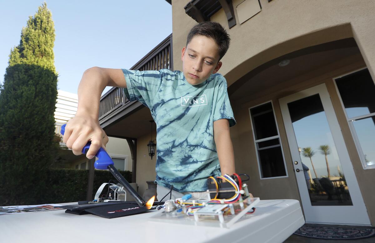 Ryan Honary, 12, prepares a demonstration of his early wildfire warning system