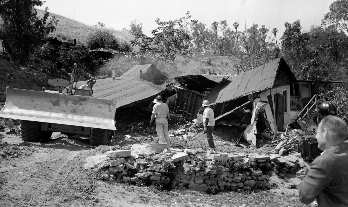 A bulldozer razes a Chavez Ravine home in 1959.