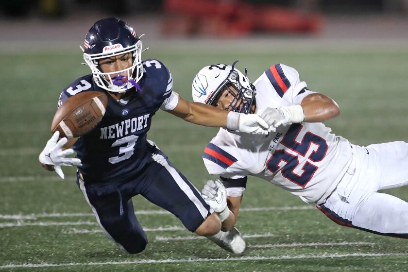 Newport Harbor reciever Cade Fegel makes one-handed catch after ball was tipped by Josepth Laffere (25) during nonleague season opener game against St. Paul, Santa Fe Springs on Friday at Davidson Feild.