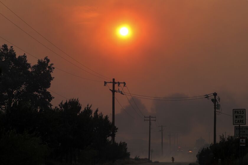 LITTLE ROCK, CA - SEPTEMBER 18: Sun is blocked by heavy smoke from Bobcat fire on Cima Mesa Road in Juniper Hills. Bobcat fire, which started Sept. 6, now rages in Juniper Hills. Wild fire that has now chewed through more than 60,000 acres, has burned through the Angeles National Forest has reached Foothills of the Antelope Valley in three different locations burning near Devil's Punchbowl nature area , the second is advancing toward Tumbleweed Road from Cruthers Creek, and the third has jumped Juniper Hills Road at Longview Road Juniper Hills on Friday, Sept. 18, 2020 in Little Rock, CA. (Irfan Khan / Los Angeles Times)