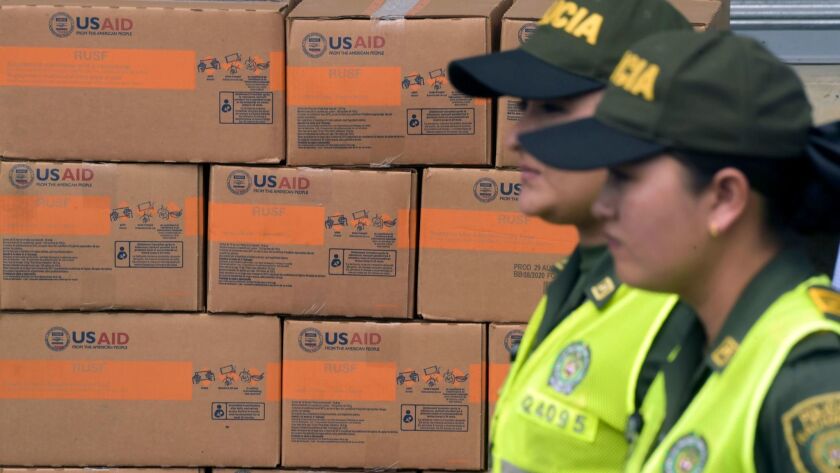 Colombian policewomen walk past boxes with U.S. humanitarian aid goods in Cucuta, Colombia, on the border with Tachira, Venezuela, on Feb. 8, 2019.