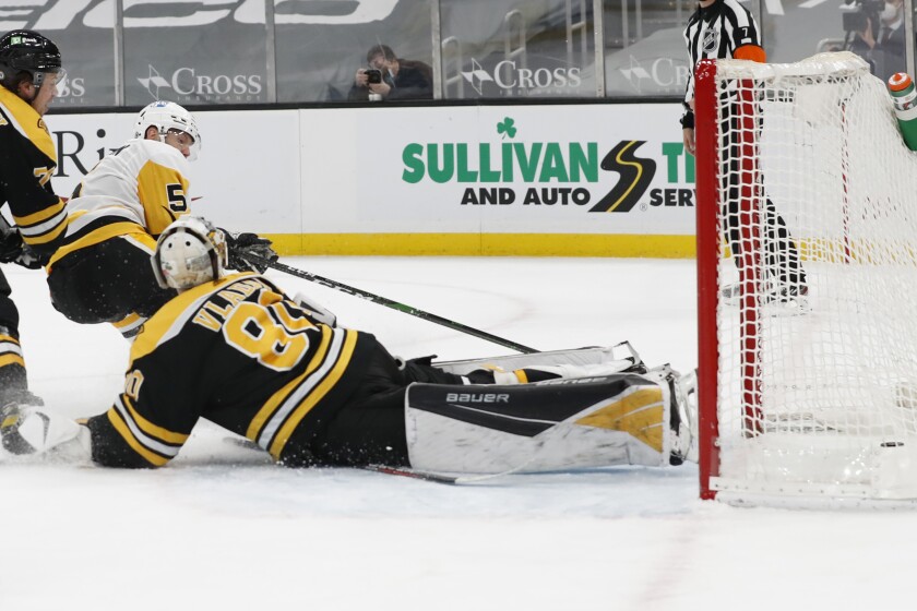 Pittsburgh Penguins' Mike Matheson tucks the puck past Boston Bruins goaltender Dan Vladar for a goal during the second period of an NHL hockey game Thursday, April 1, 2021, in Boston. (AP Photo/Winslow Townson)